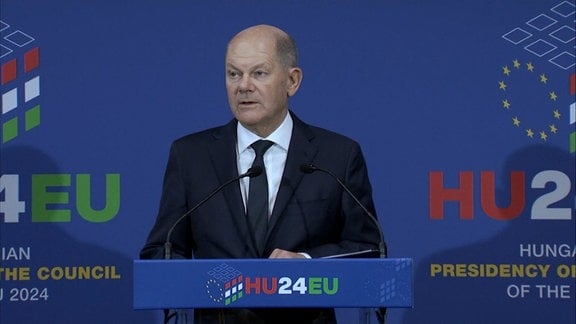 Bundeskanzler Olaf Scholz an einem Rednerpult