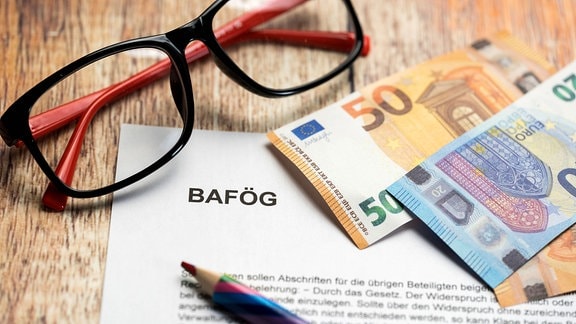 Symbolbild BAFÖG. Brille mit Euro-Geldscheinen.