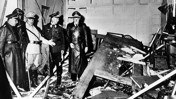 Reichsmarschall Hermann Göring und der Chef der "Kanzlei des Führers", Martin Bormann, begutachten die Zerstörung im Raum der Karten-Baracke im Führerhauptquartier Rastenburg