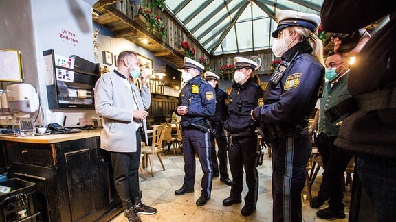 Corona-Kontrolle durch Polizisten in einem Restaurant
