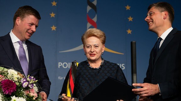 Der Stiftungsratsvorsitzende der Point Alpha Stiftung, Stefan Heck (l), und der Präsident des Kuratoriums Deutsche Einheit, Christian Hirte (r), überreichen den Point-Alpha-Preis an die ehemalige litauische Staatspräsidentin Dalia Grybauskaite.