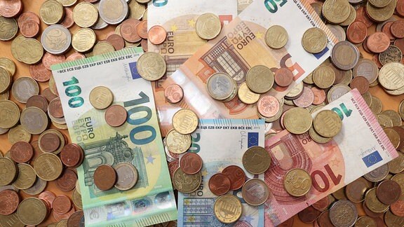 Euro-Banknoten und -Münzen liegen auf einem Tisch