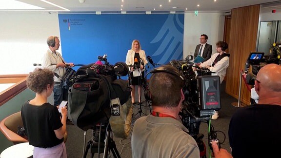 Bundesinnenministerin Nancy Faeser vor vielen Mikrofonen von Pressevertretern