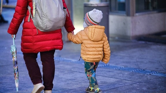 Eine Mutter mit Kind gehen spazieren.