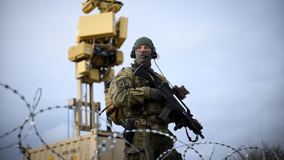 Ein Bundeswehr-Soldat steht vor einem Abwehrsystem.