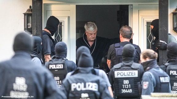 Polizei steht vor dem Hauseingang von Jürgen Elsässer