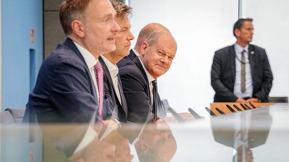 Bundeskanzler Olaf Scholz (SPD, r-l), Robert Habeck (Bündnis 90/Die Grünen), Bundesminister für Wirtschaft und Klimaschutz, und Christian Lindner (FDP), Bundesminister der Finanzen, nehmen an einer Pressekonferenz zum Haushaltsplan 2025 teil. 