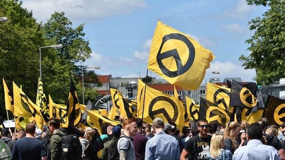 Anhänger der rechtsradikalen «Identitären Bewegung» stehen mit Fahnen auf der Brunnenstraße in Halle (Saale). 