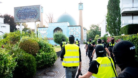 Einsatzkräfte der Polizei gehen während einer Razzia auf das Gelände vom Islamischen Zentrum Hamburg mit der Imam Ali Moschee (Blaue Moschee) an der Außenalster.