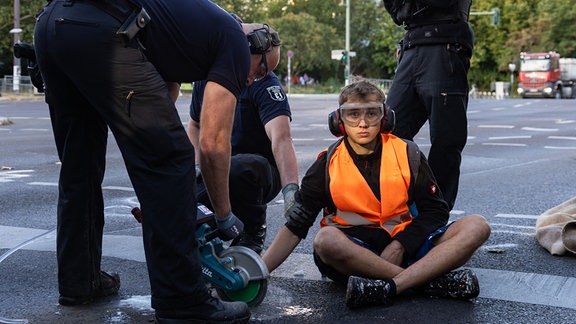Polizeikräfte lösen einen Aktivisten von der Straße. Am Dienstag fanden erneut Protestaktionen der Klima-Aktivisten der Letzten Generation in Berlin statt.