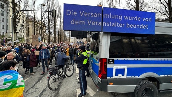 "Die Veranstaltung wurde von dem Veranstalter beendet" steht auf einer auf ein Polzeifahrzeug montierten Anzeigetafel. 