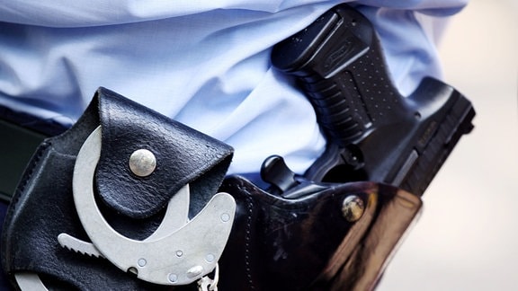 Ein Polizist mit Handschellen und Pistole am Gürtel 