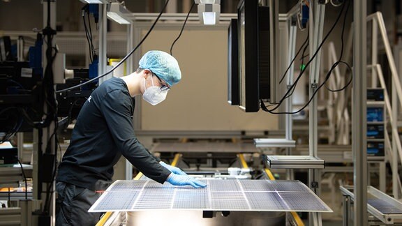 Ein Mitarbeiter steht bei der Qualitätskontrolle an einer Produktionslinie für Solarmodule im Werk der Meyer Burger Technology AG