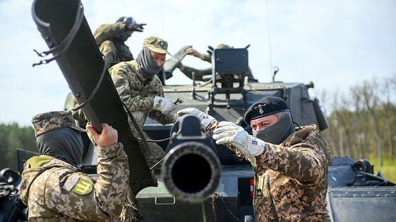 Ukrainische Soldaten arbeiten an der Panzerkanone eines Kampfpanzers vom Typ Leopard 1 A5. 