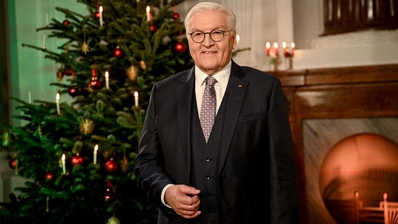 Frank-Walter Steinmeier steht vor einem Weihnachtsbaum.