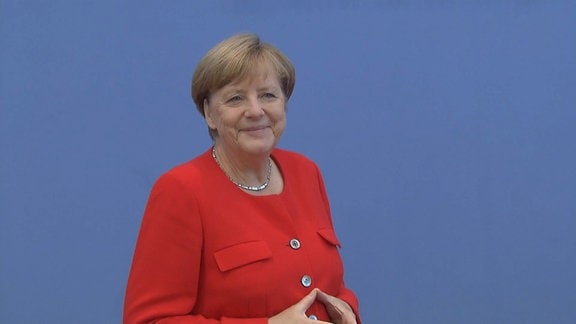 Ex-Bundeskanzlerin Angela Merkel macht mit Händen ihre berühmte Raute