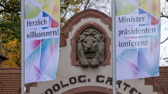 Fahnen mit den Schriftzügen "Herzlich willkommen" und "Ministerpräsidentenkonferenz" vor dem Eingang des Leipziger Zoos