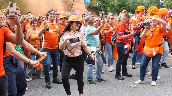 Niederländische Fans tanzen bei einem Fanmarsch in Hamburg.
