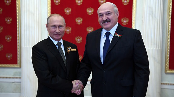 Der russische Präsident Wladimir Putin und Belarus Präsident Alexander Lukashenko geben sich die Hand. Putin hatte ihn für den 24. Juni 2020 nach Moskau zur Siegesparade eingeladen