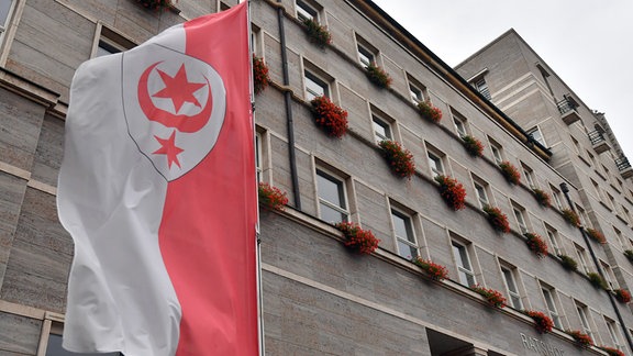 Rathaus in Halle 2019, im Vordergrund ist eine Flagge mit dem Stadtwappen.