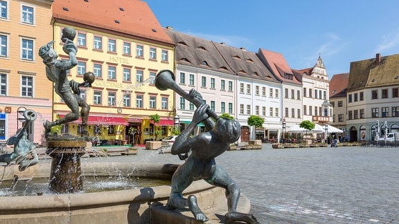 Brunnen auf dem Torgauer Marktplatz, dahinter das Hotel Goldener Anker.