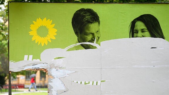 Ein zerstörtes Wahlplakat von Bündnis 90/Die Grünen mit den Portraits von Robert Habeck und Annalena Baerbock