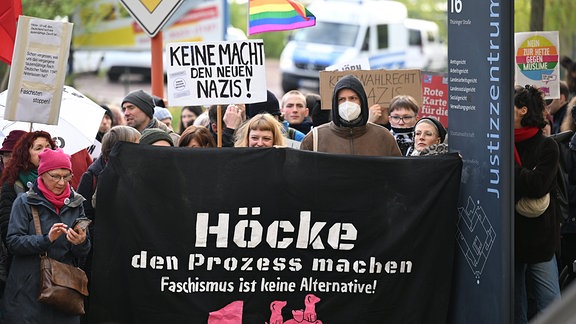 Demonstranten stehen vor dem Justizzentrum und halten ein Plakat mit der Aufschrift "Höcke den Prozess machen - Faschismus ist keine Alternative!"
