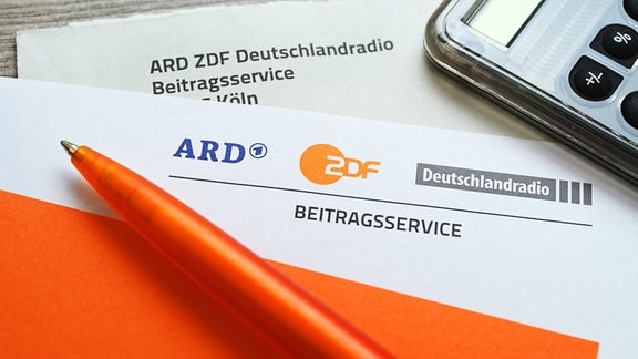 Brief des ARD ZDF Deutschlandradio Beitragsservice mit Taschenrechner und Kugelschreiber
