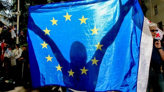 Ein Demonstrant hält eine EU-Fahne während eines Protestes der Opposition gegen das Gesetz über ausländische Einflussnahme vor dem Parlamentsgebäude.