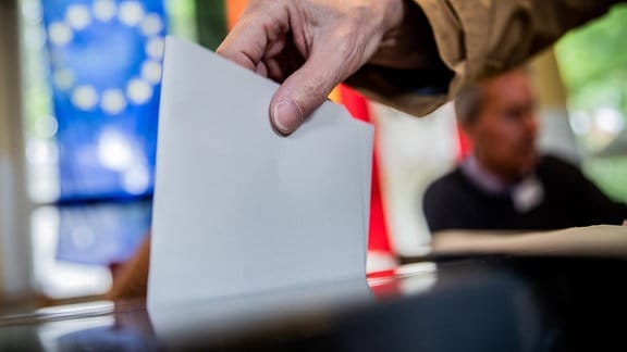 Ein Mann wirft seinen Stimmzettel in die Wahlurne