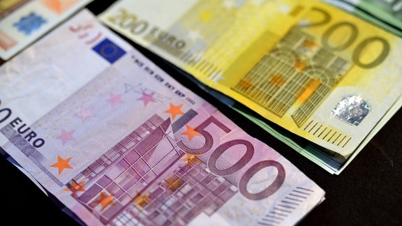Euro-Scheine in den Stückelungen 200 und 500 Euro liegen gebündelt auf einem Tisch.