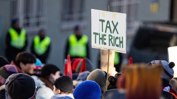 Auf einem Schild steht «Tax the richt». Hunderte Menschen demonstrierten für Klimagerechtigkeit unter dem Titel «Strike WEF» in Davos.