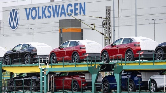 Elektrofahrzeuge verschiedener Typen stehen auf einem Transportzug vor der Volkswagen Sachsen GmbH in Zwickau. 