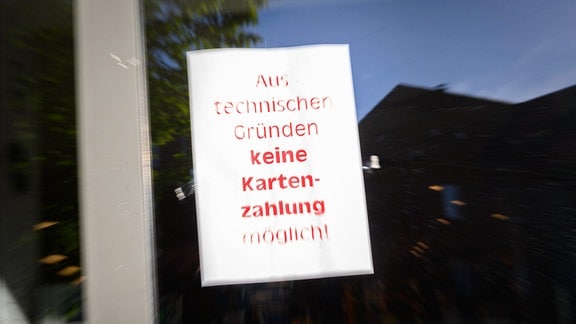 Ein Schild mit der Aufschrift "Aus technischen Gründen keine Kartenzahlung möglich!" hängt am Eingang eines Supermarktes