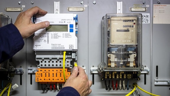 Ein Zaehlermonteur im Auftrag der EWZ installiert einen Smart Meter-Stromzaehler neben einem alten Stromzaehler.