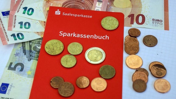 Sparkassenbuch der Saalesparkasse mit Euro Banknoten und Euro Münzen