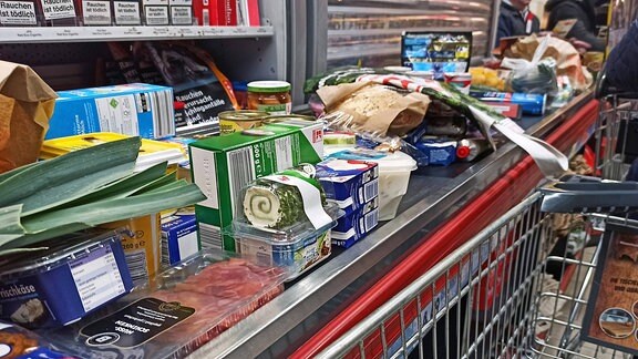 Waren liegen in einem Supermarkt auf einem Kassenband