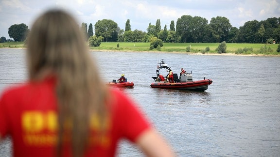 Ein Mitglied der Deutschen-Lebens-Rettungs-Gesellschaft (DLRG) beobachtet eine Rettungsübung auf dem Rhein.