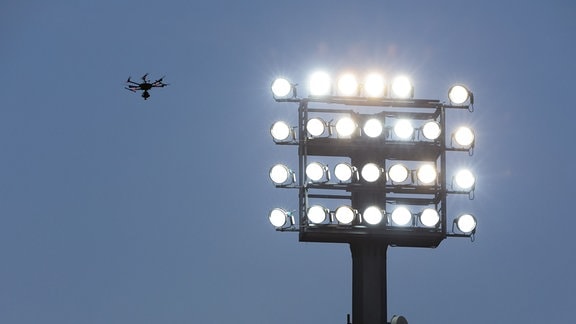 Eine Drohne ist neben dem Flutlicht zu sehen.