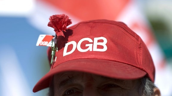 Ein Mann mit einem Basecap mit DGB-Aufdruck und einer roten Nelke