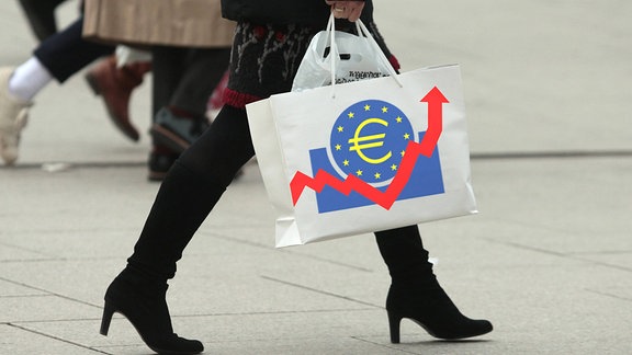 Frau trägt eine Tragetasche mit Emblem der EZB und aufwärts gerichtetem Pfeil