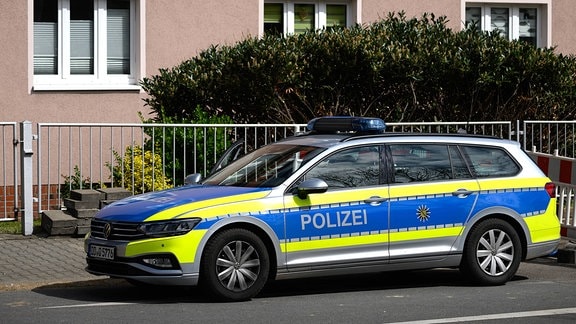 Ein Polizeiauto steht vor einem Wohnhaus