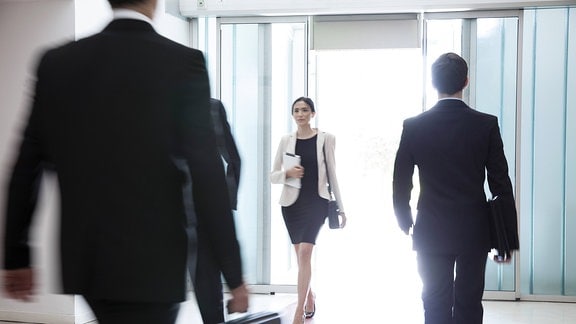 Geschäftsfrau geht durch die Lobby eines Bürogebäudes 