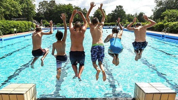 Schüler springen in ein Freibad
