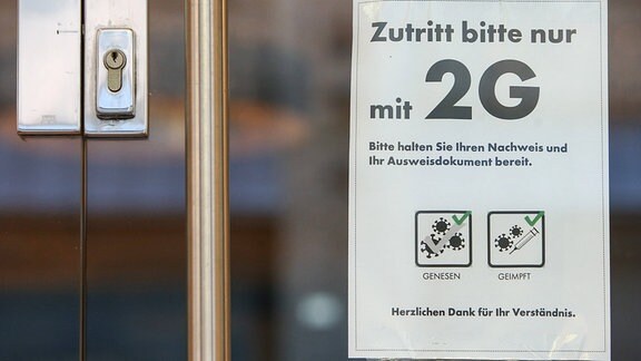 Hinweisschild auf die 2G-Regel an einer Ladentür.