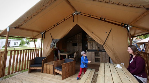 Eine junge Frau und ein Junge in einem Glamping-Lodgezelt