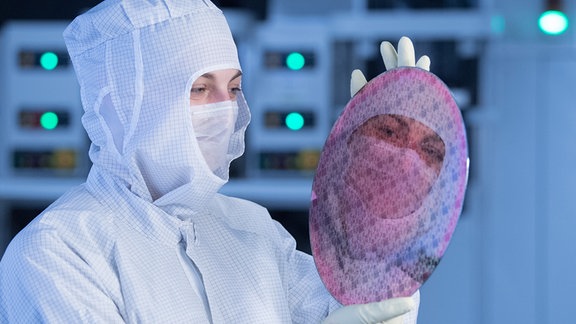 Auszubildende hält 2019 in einem Automatisierungslabor einen Test-Wafer.