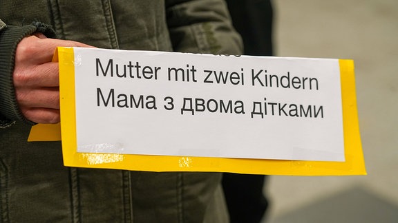Auf einem zweisprachigen Schild wird eine Unterkunft für eine Mutter mit zwei Kindern angeboten.