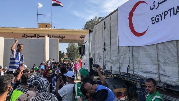 Ägyptische Freiwillige feiern, als die ersten Lastwagen mit Hilfsgütern für den Gaza-Streifen den Grenzübergang Rafah passieren