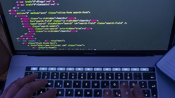 Der html-Code für die Programmierung einer Internetseite ist auf dem Monitor eines Laptops zu sehen.